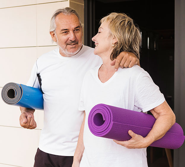 Older couple exercising together in a garden