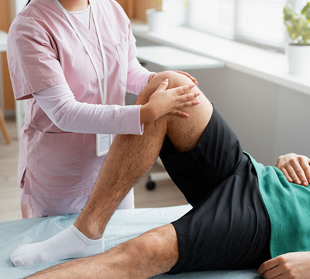 Orthopedic specialist holding a patient’s right knee up and bent during rehabilitation