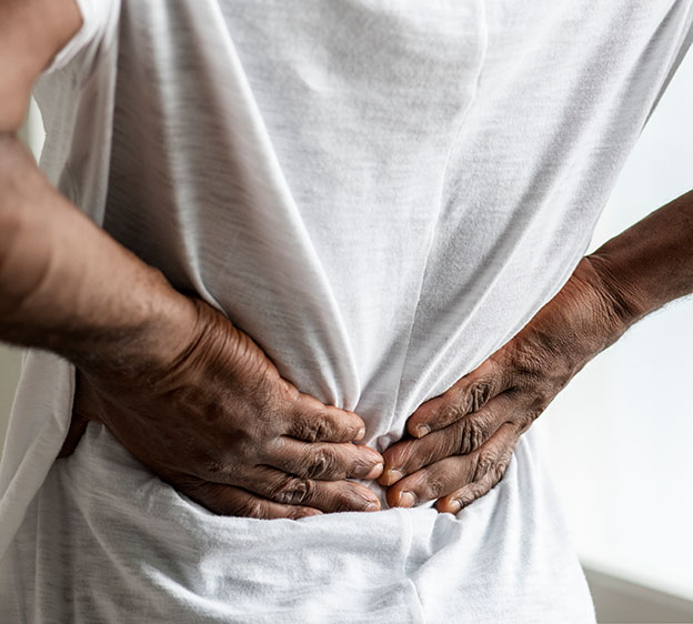 Older Black man holding his lower back with his hands