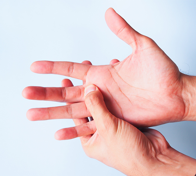 Man with hand pain and massages finger base on palm near the base of the middle finger