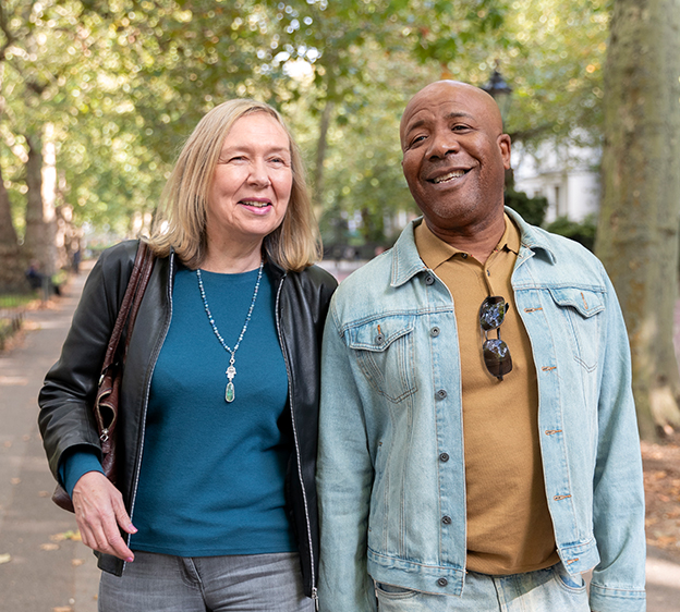 An older woman and an older man walking together and holding hands