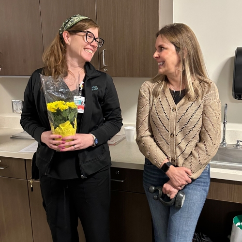 Annie Loughlin and Jill Scheper smile at each other at a surprise DAISY Award ceremony for Annie