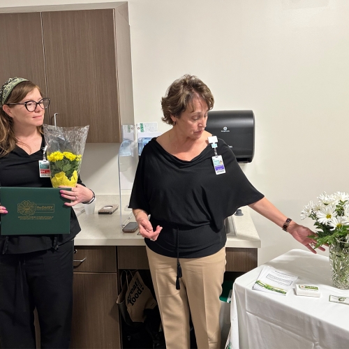 Karen Carroll, Chief Nursing Officer at Beaufort Memorial, presents Annie Loughlin, RN, BSN with a vase of daisies