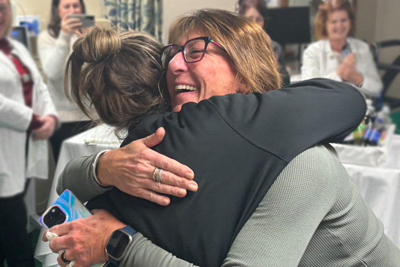 Tammy Olmstead, who nominated Nancy for the DAISY Award, hugs Nancy at the surprise ceremony on December 2, 2024