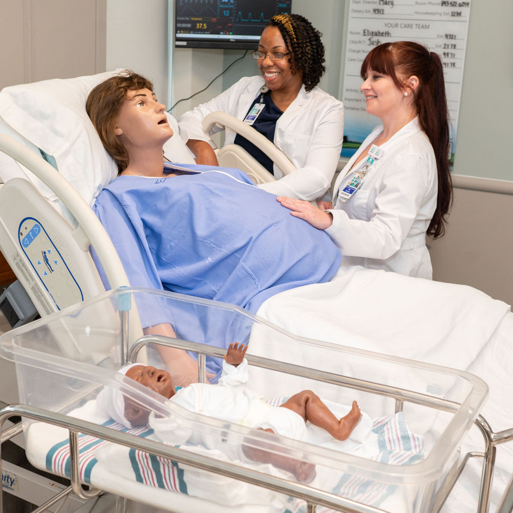 Nurses interacting with labor & delivery patient simulation manikin