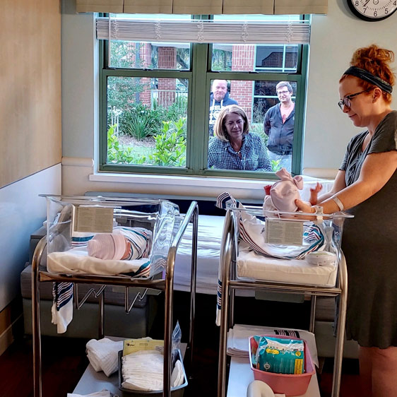 Showing grandma the babies through the window