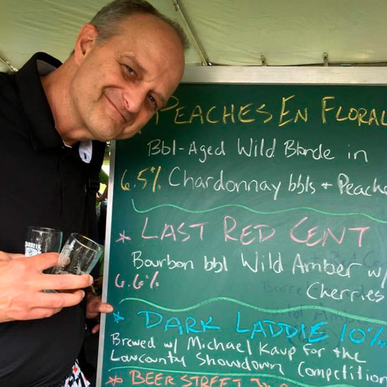 Dr. Michael Kaup photographed in front of a chalk sign advertising drinks at the Hilton Head Island Wine and Food Festival