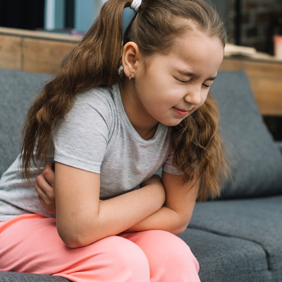 Child holding stomach in pain