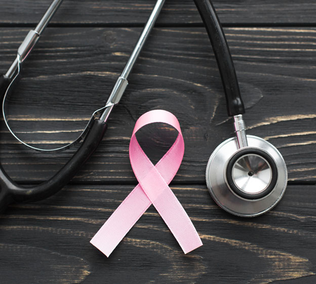 A styled shot of a stethoscope surrounding a pink ribbon symbolizing breast cancer awareness