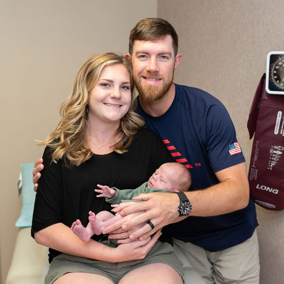 A woman named Shannan Sanders photographed with her husband and their newborn baby