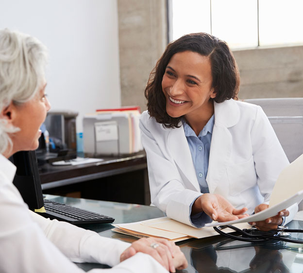 A female cancer patient and a female physician review medical documents.