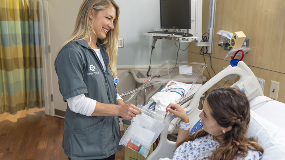 pharmacy tech delivering medications to patient's bedside