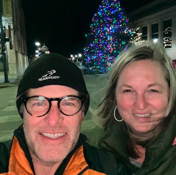 Dr. John Krcmarik and his wife taken as a selfie with a Christmas tree in the background