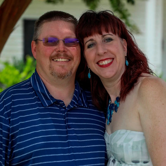 A nurse named Carrie McClure photographed with her partner and smiling at the camera