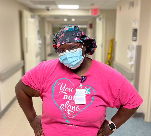 Hyacintha Gordon wearing scrubs and a mask looking toward the camera