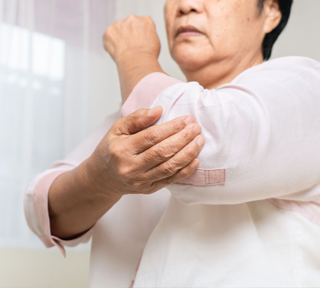 Older woman holding her elbow in pain