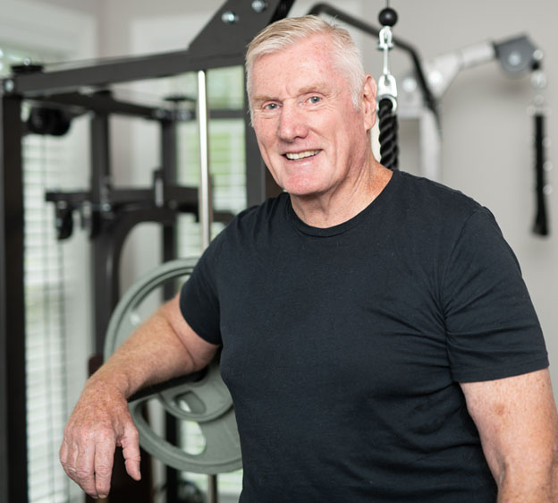 Dave Collins poses in front of fitness equipment