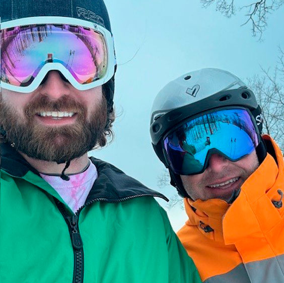 Dr. John Krcmarik photographed in ski clothing surrounded by snow with his son