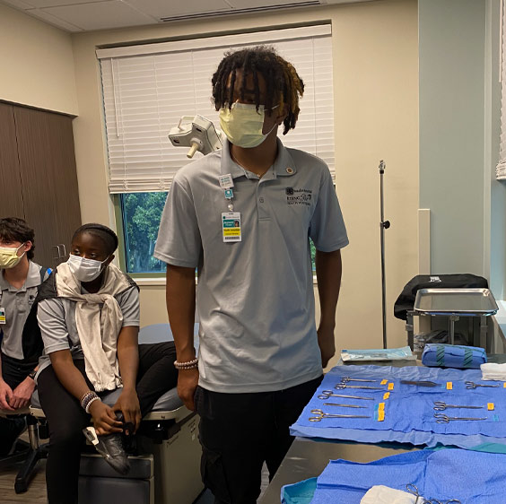 Jaysun Puryear in a classroom in front of medical equipment