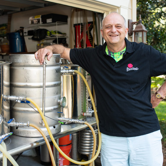 Dr. Michael Kaup standing next to his full beer brewing system