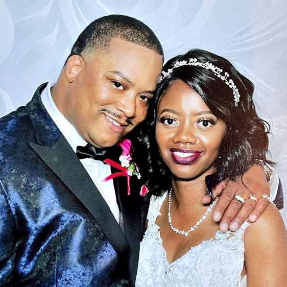 Breast cancer survivor Tiera White in her wedding dress standing next to her new husband, Donald