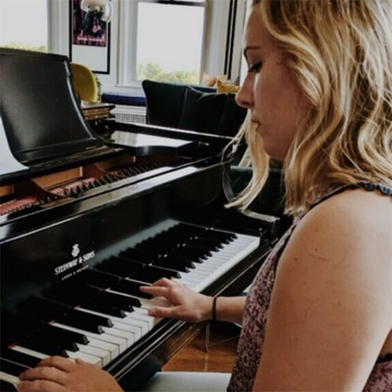 Samantha Bruns looking down and playing the piano