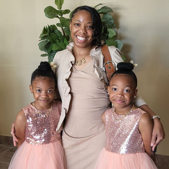 Joy Solomon poses with her twin daughters