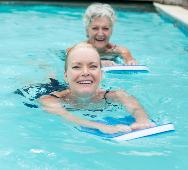 women using kickboards in a pool