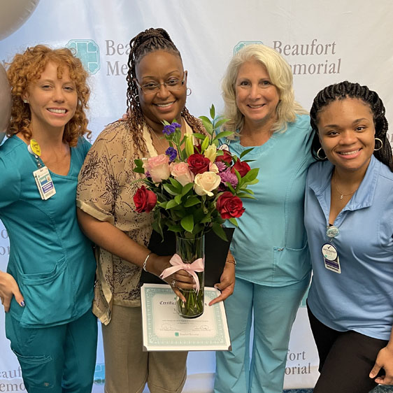 Group poses with PATH graduate holding flowers