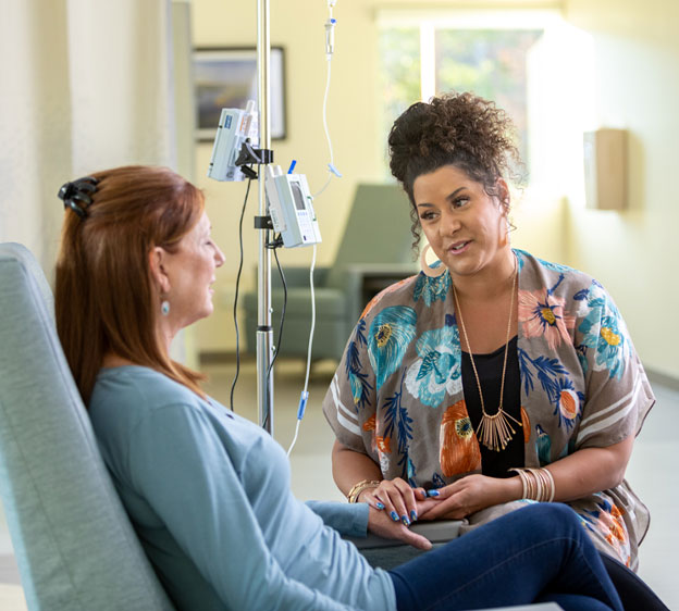 A Beaufort Memorial nurse navigator speaks with a patient receiving infusion therapy