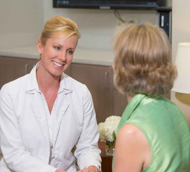 A female oncologist speaks with a breast cancer patient.