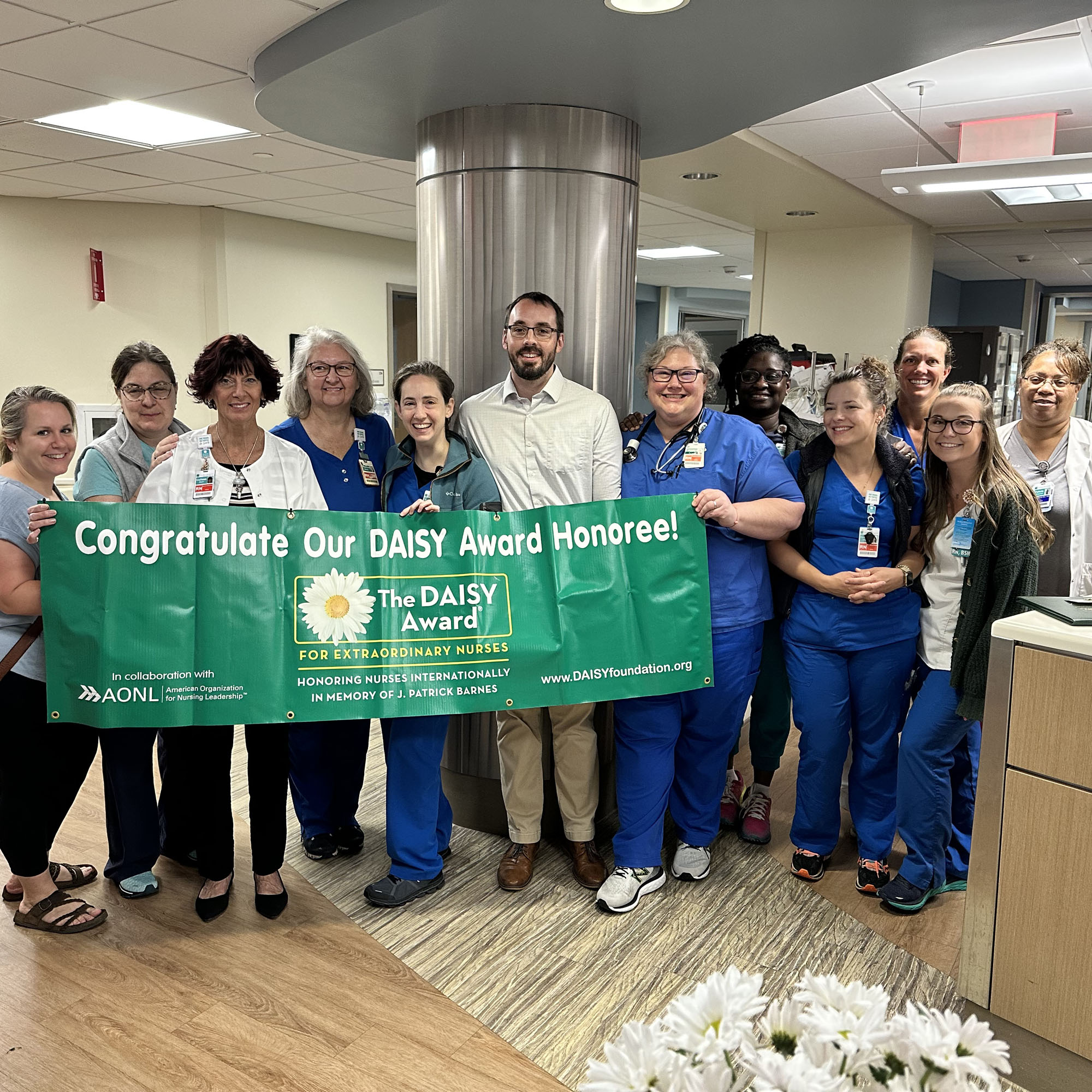 ICU team poses with DAISY Award banner