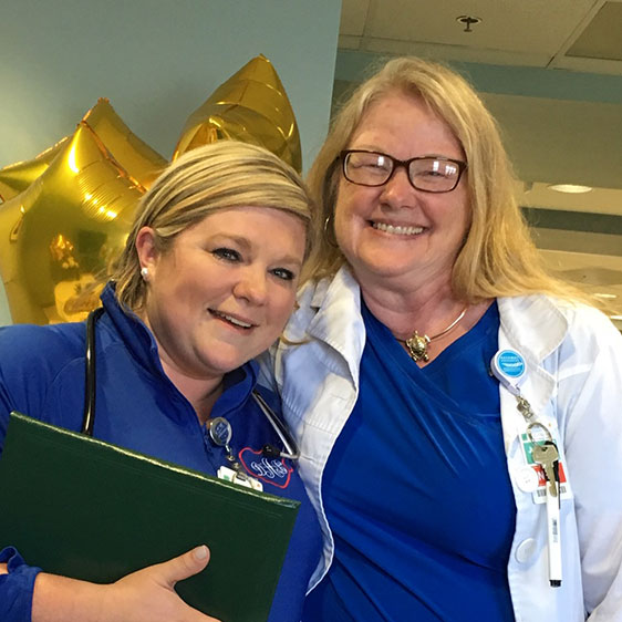 Two medical professionals posing for a photograph and smiling