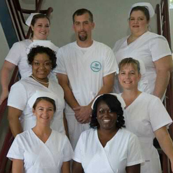 A group photo of nurses wearing white nursing uniforms