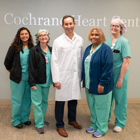 Cath Lab team poses around Dr. Smalheiser