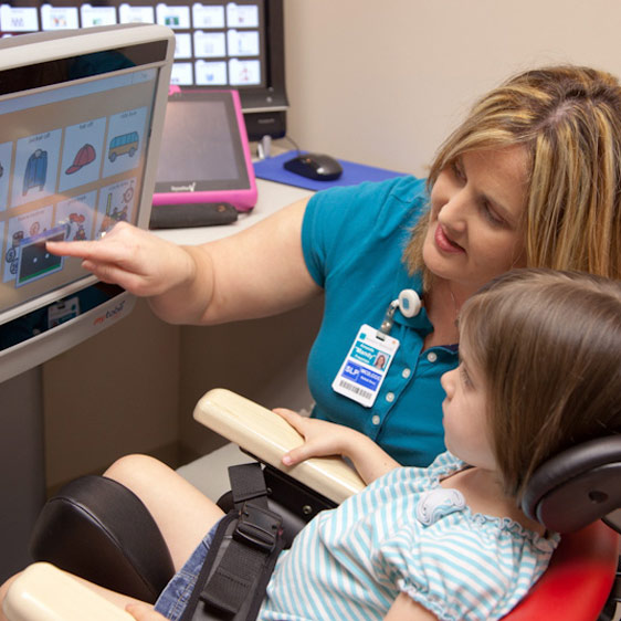 A pediatric occupational therapist at Beaufort Memorial works with a little girl on a computer