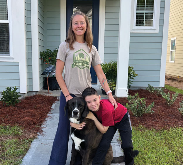 Clinical Nutrition Manager Roxanne Davis photographed in front of a house with her son.