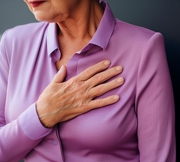 A woman wearing a purple button-down blouse and clutching her chest with her right hand