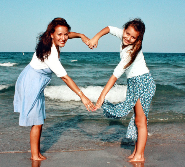 mom &amp; daughter forming a heart with their arms