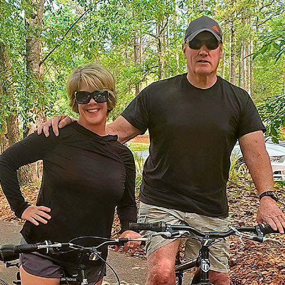 David Collins and his wife, Maureen, pose while sitting on bikes