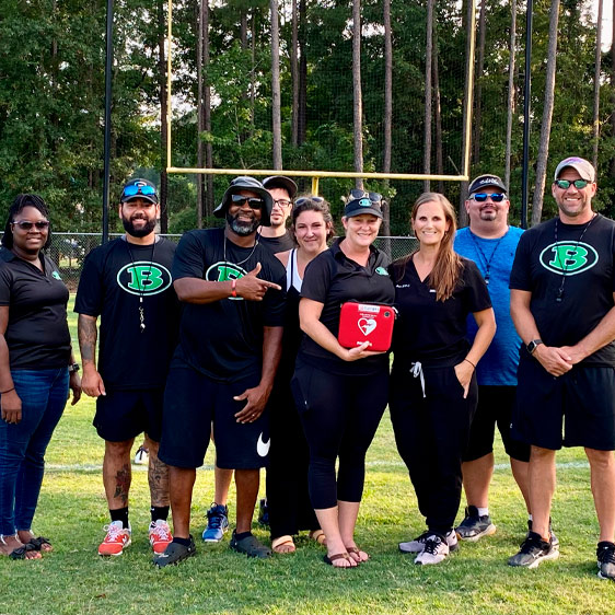 Beaufort Memorial primary care provider Kimberly Bean, MSN, FNP-C, and her team on a football field