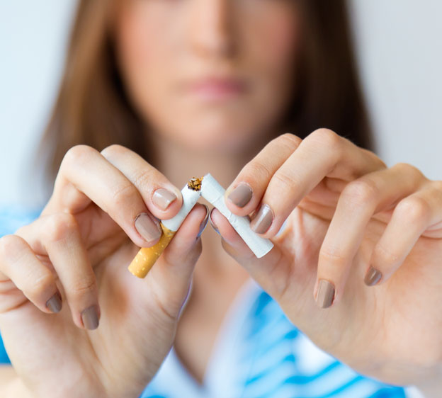 A woman breaks her cigarette in half.