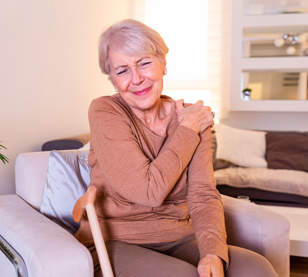 Older woman holding her shoulder in pain