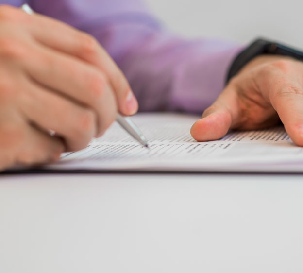 Person writing on a paper attached to a clipboard