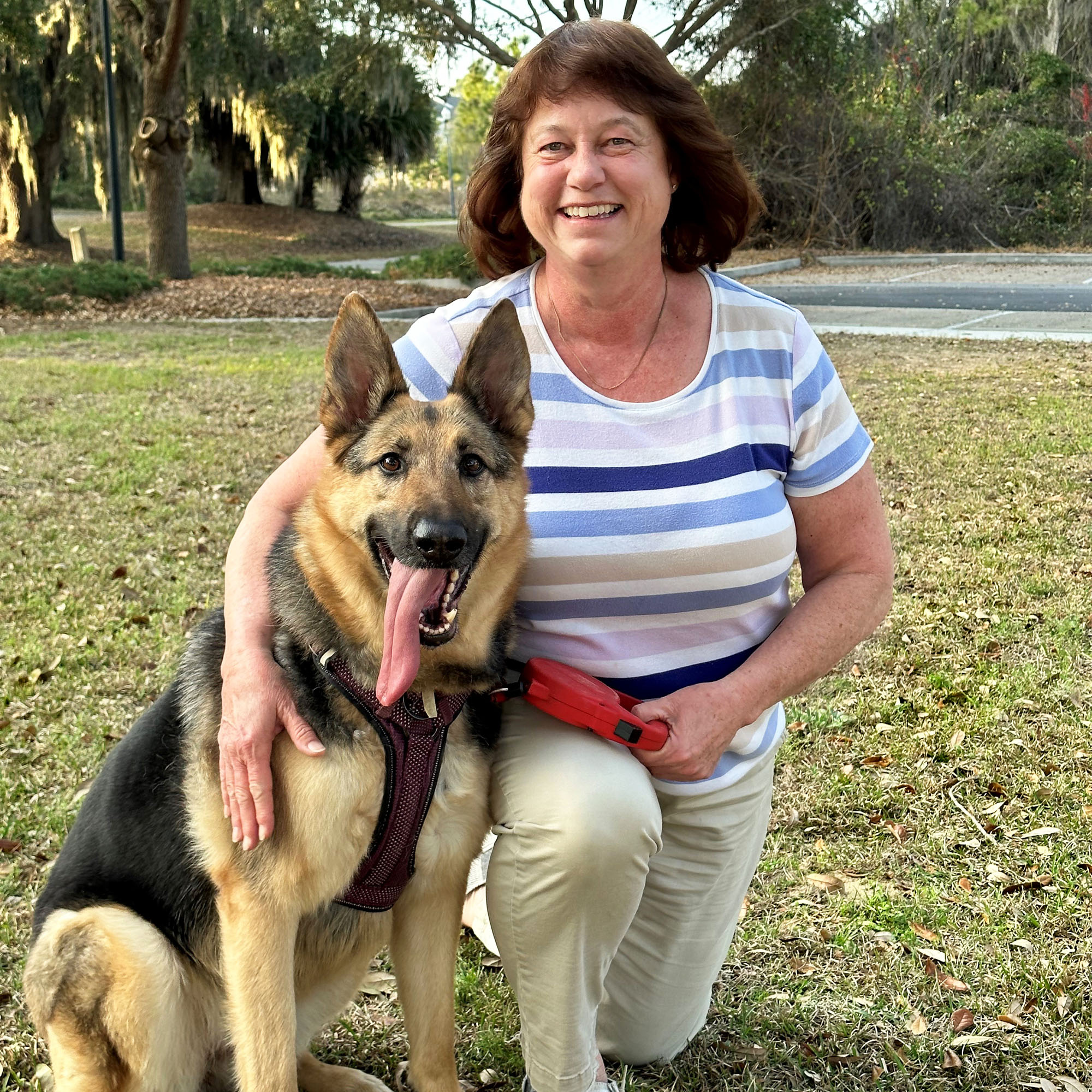 Ashley Sanders poses with her dog while kneeling