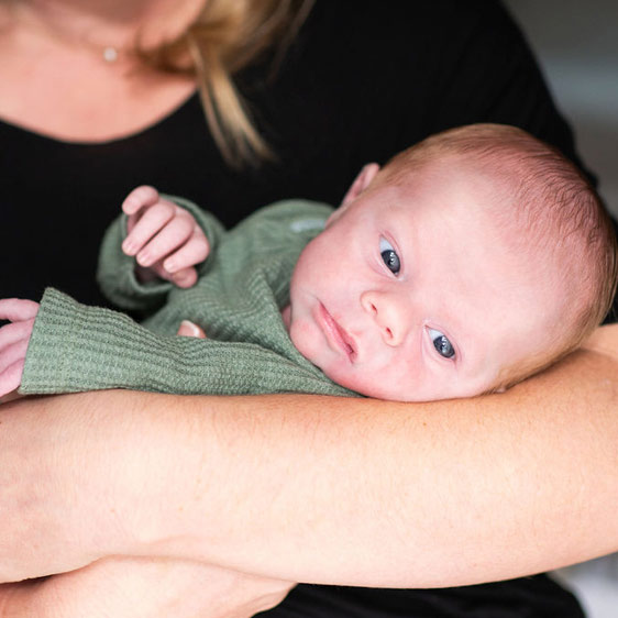 A newborn named River Douglas Sanders being held by his mother