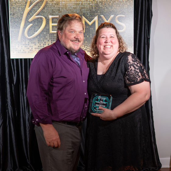 Nikki Newman holds her Bemmy Award and stands next to her husband, Paul