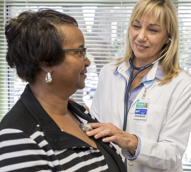 nurse practitioner checking woman's heart