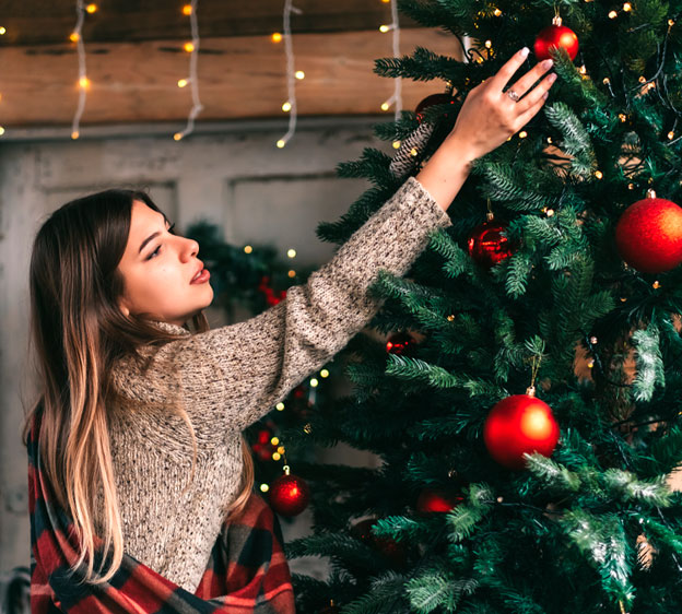 Woman hanging an ornament on a Christmas tree