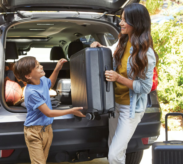 mother and son loading luggage into car